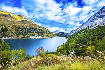 Glacial lake with clear cold water. Mountain Lake Lago di Fedaia, Dolomites. The magic and harmony of the Dolomites. The concept of ecological and extreme tourism