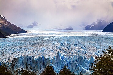 Argentine province of Santa Cruz. The spectacular glacier Perito Moreno in the Argentine part of Patagonia. The concept of ecological and extreme tourism. The cloudy sky covers the horizon