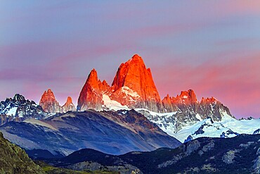 The grand crimson dawn over the mountain Fitzroy. Mountain peak in Patagonia. Magnificent mountain range, illuminated by the sunrise sun. The concept of extreme, active and photo tourism