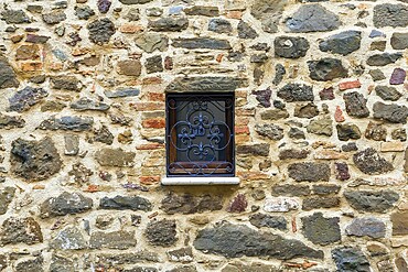 Cloudy autumn day in Tuscany. The small town of Montalcino. The beautiful decor element of a small window - metal window grill. The concept of cognitive, active and photo tourism
