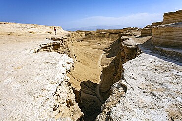 Woman tourist in a red sweater admires the landscape. The Judean Desert. Israel. Interesting walk among picturesque hills, cliffs and limestone gorges. Dead Sea