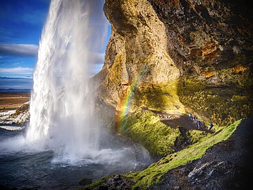 Seljalandsfoss, a majestic and powerful waterfall in Iceland in a sunny spring day with a raibow