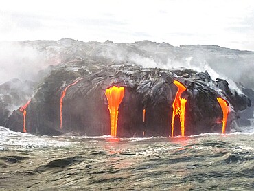 Close up of Kilauea Volcano, Hawaii Volcanoes National Park, also known Kilauea Smile because from 2016 seems to smile, erupting lava into Pacific Ocean, Big Island. Scenic sea view from the boat