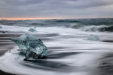Ice floes on the black sea sand and the coast Jokulsarlon