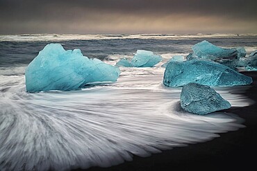 Ice floes on the black sea sand and the coast Jokulsarlon