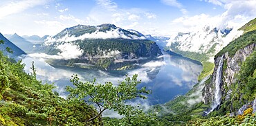 Panoramic view, Gjerdefossen waterfall, at Ørnesvingen viewpoint, atmospheric clouds over the fjord in the morning light, at Geirangerfjord, near Geiranger, Møre og Romsdal, Norway