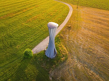 Modern building on a field with a curved path in the evening light