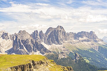 Imposing mountain range with dramatic sky and clouds, green plains below, hike to the Schlehrn, Alpe di Siusi, Dolomites, South Tyrol, Italy