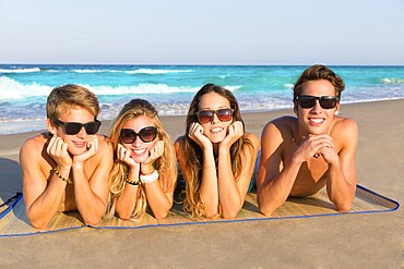 Beach friends together tourits portrait on the sand smiling happy