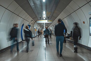 Tourists and commuters navigating an underground corridor in London, united kingdom, surrounded by modern architecture and vibrant energy