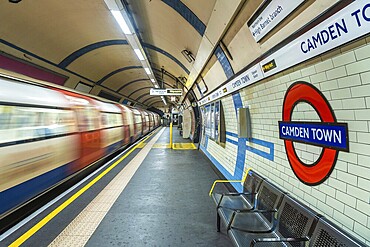Motion blur of a London underground train arriving at Camden town station with its distinctive tiled walls and roundel