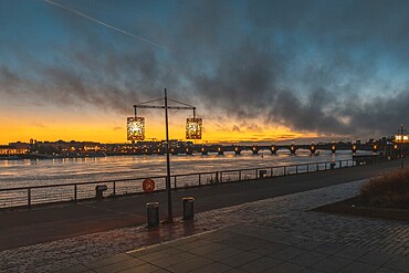 Scenic view of bordeaux cityscape illuminating at sunset over garonne river with pont de pierre bridge in the background