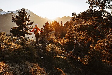 Hiker in the Allgäu at sunset in spring on the Zirmgrat near Pronten in the Allgäu