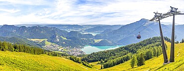 Landscape in the mountains, with lake and cable car, in the valley lake Wolfgangsee, in the background mountain Schafberg, view from the mountain Zwolferhorn