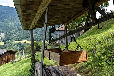 Traditional material ropeway with wooden container on a South Tyrolean mountain farm