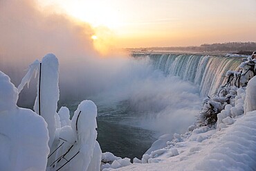 The Canadian Horseshoe Falls in on a cold winters day with snow and ice covering the railings and walkway in Niagara Falls, Ontario, Canada, North America