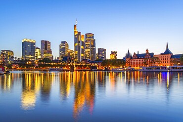 Illuminated Frankfurt City Downtown Skyscrapers at Evening Twilight and Reflection in Main River. Blue Hour. Hesse, Germany