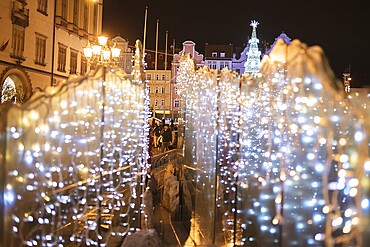 Christmas fair in the market square of Wroclaw (in Poland) with illumnated christmas tree over the fountain's lights
