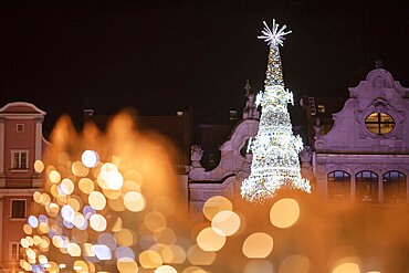Christmas fair in the market square of Wroclaw, Poland. Christmas tree behind lights which gift beautiful bokeh