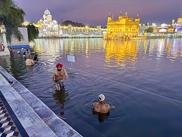 Worshippers bathe in an artificial lake, the Amrit Sarovar, in front of the Harmandir Sahib or Hari Mandir (temple of God), usually called the Golden Temple, a Sikh sanctuary in Amritsar, Punjab, India