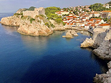Panorama of a rocky coast with fortress, buildings and deep blue sea in sunny weather, Dubrovnik, Croatia