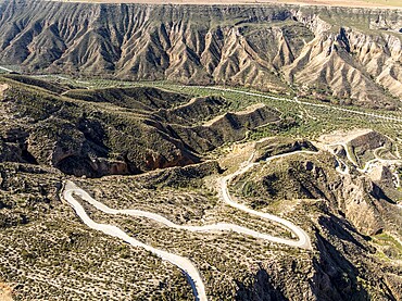Canyons and gorges near village Gorafe, winding road, aerial view, Gorafe Desert, UNESCO Granada Geopark, Granada province, Andalusia, Spain