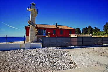 Red house with lighthouse by the sea under a clear blue sky, Mediterranean atmosphere, lighthouse Zadar, Central Dalmatia, Croatia