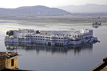 Lake Pichola with lake palace (Jag Niwas), Udaipur, Rajasthan, North India, Asia, A large palace on a lake in front of a mountain landscape, India