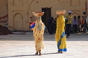 Fort Amber, Amber, near Jaipur, Rajasthan, North India, India, Asia, Two woman in traditional saris carrying baskets on their heads in an open courtyard