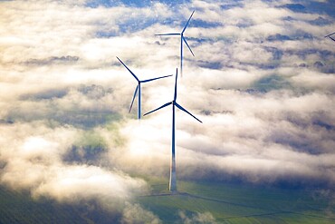 Wind turbines in the wintry morning mist protrude from the fog layer in the Haltern and Marl area. North Rhine-Westphalia, Germany