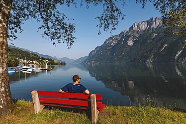 Sitting, red bench, lake, morning sun, Switzerland