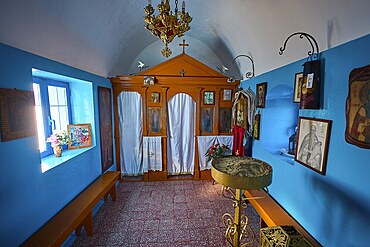 The interior of the church features icons and decorative elements in blue and orange, chapel, church, Agios Isidoros, rocky islet, Gourna Bay, Kokkali, Leros, Dodecanese, Greek Islands, Greece