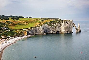 Famous cliff formation with grassy landscape and calm sea, The cliffs and alabaster coast of Etretat in Normandy France