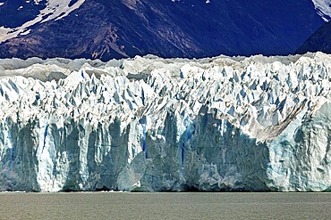 Detailed view of a massive blue glacier against a mountain backdrop, The Perito Moreno glacier in Argentina