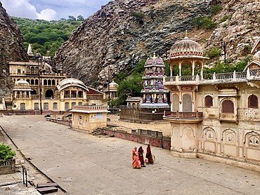 Historic temple complex surrounded by rocks with elaborately decorated buildings and figures, Galtaji Hanuman Temple, Jaipur, Rajasthan, India