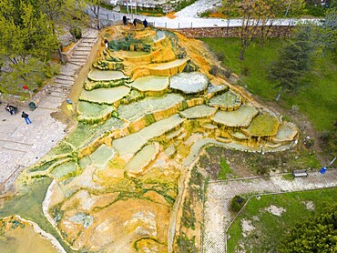 Multicoloured natural mineral terraces with water accumulations in a park landscape, aerial view, Karahayıt Kırmızı Su, Red Spring, Pamukkale, Denizli, Turkey