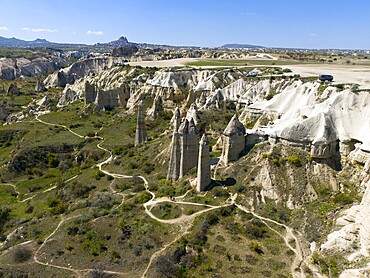 A hilly landscape with iconic rocks and roads in Cappadocia, aerial view, Love Valley, Göreme National Park, Göreme Tarihî Millî Parkı, Nevsehir Province, Nevşehir, Cappadocia, Cappadocia, Cappadocia, Cappadocia, Central Anatolia, Turkey