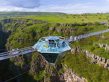 A glass platform with people stands on a bridge overlooking a green gorge, surrounded by picturesque nature, Diamond Bridge, Diamond Glass Bridge, world's longest free-hanging structure, Dashbashi Gorge, Khrami River, Tsalka Nature Reserve, Kartlia, Georgia