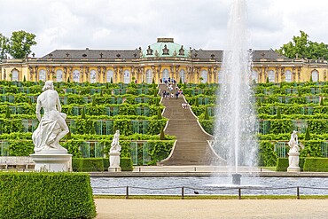 Symmetrical view with fountain in front of Sanssouci, flanked by sculptures, potsdam, brandenburg, germany
