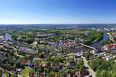 Fascinating aerial view of Donauwörth with its characteristic red roofs and historic buildings. A striking building with a tower stands out in the foreground, surrounded by well-tended green spaces and trees. The town stretches along the rolling hills and offers a picturesque atmosphere with idyllic streets, a historic townscape and expansive landscapes. Donauwörth, Swabia, Bavaria, Germany