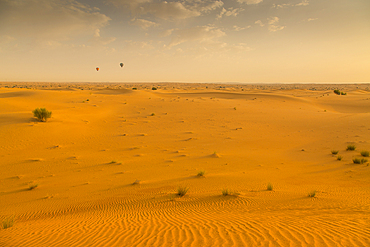 Hot air balloons over sand dunes at sunrise in the Dubai Desert, Dubai, United Arab Emirates, Middle East