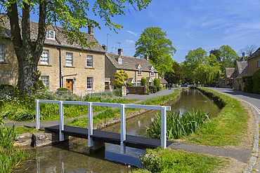 Cottages and footbridge over the River Eye in Lower Slaughter, Cotswolds, Gloucestershire, England, United Kingdom, Europe