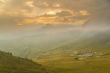 View of landscape and winding road from Marmolada Pass at sunset, South Tyrol, Italian Dolomites, Italy, Europe