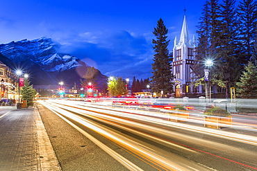 Trail lights on Banff Avenue and St. Paul's Presbyterian Church, Snow Peak visible through clouds, Banff, Banff National Park, Alberta, Canada, North America