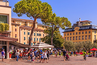 View of restaurants and pastel coloured architecture in Piazza Garibaldi, Riva del Garda, Lake Garda, Trentino, Italian Lakes, Italy, Europe