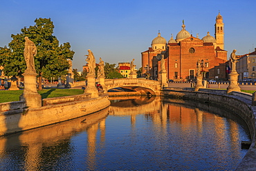 View of statues in Prato della Valle during golden hour and Santa Giustina Basilica visible in background, Padua, Veneto, Italy, Europe