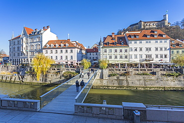 View of buildings along Ljubljanica River and Castle visible in background, Ljubljana, Slovenia, Europe