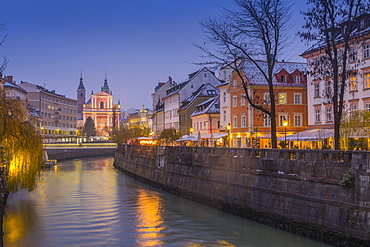 Ornate facade of Franciscan Church of the Annunciation and Ljubljanica River at dusk, Ljubljana, Slovenia, Europe