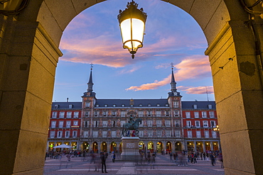 View of Casa de la Panaderia in Plaza Mayor through archway at dusk, Madrid, Spain, Europe