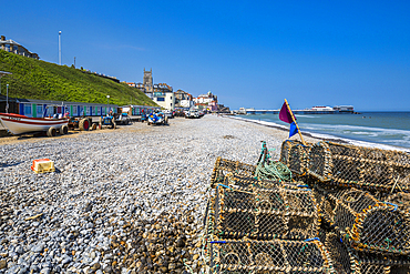 View of fishing baskets on the beach and Parish Church overlooking pier on a summer day, Cromer, Norfolk, England, United Kingdom, Europe